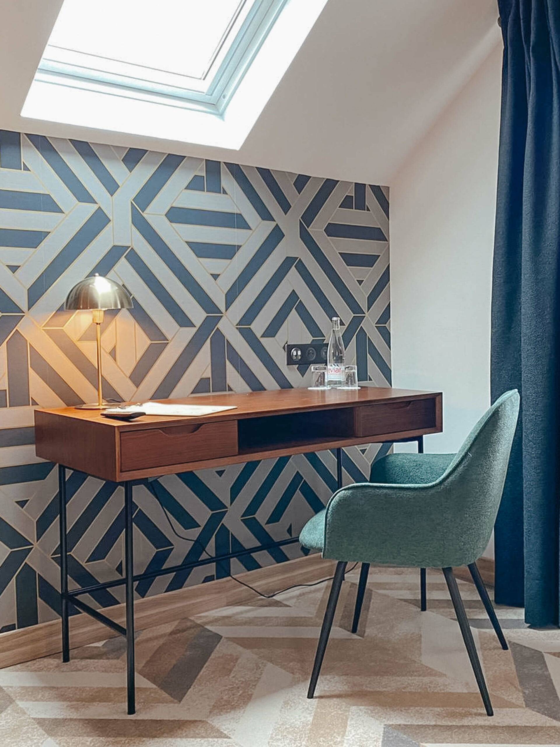Rénovation d’une maison ancienne en chambre d’hôtes au Merlerault dans le perche normand, esprit art déco coin bureau Rénovation d’une maison ancienne en chambre d’hôtes au Merlerault dans le perche normand, esprit art déco avec du papier peint à motifs géométriques, du laiton, un bureau en bois d’acacia et métal noir et un fauteuil en tissu vert