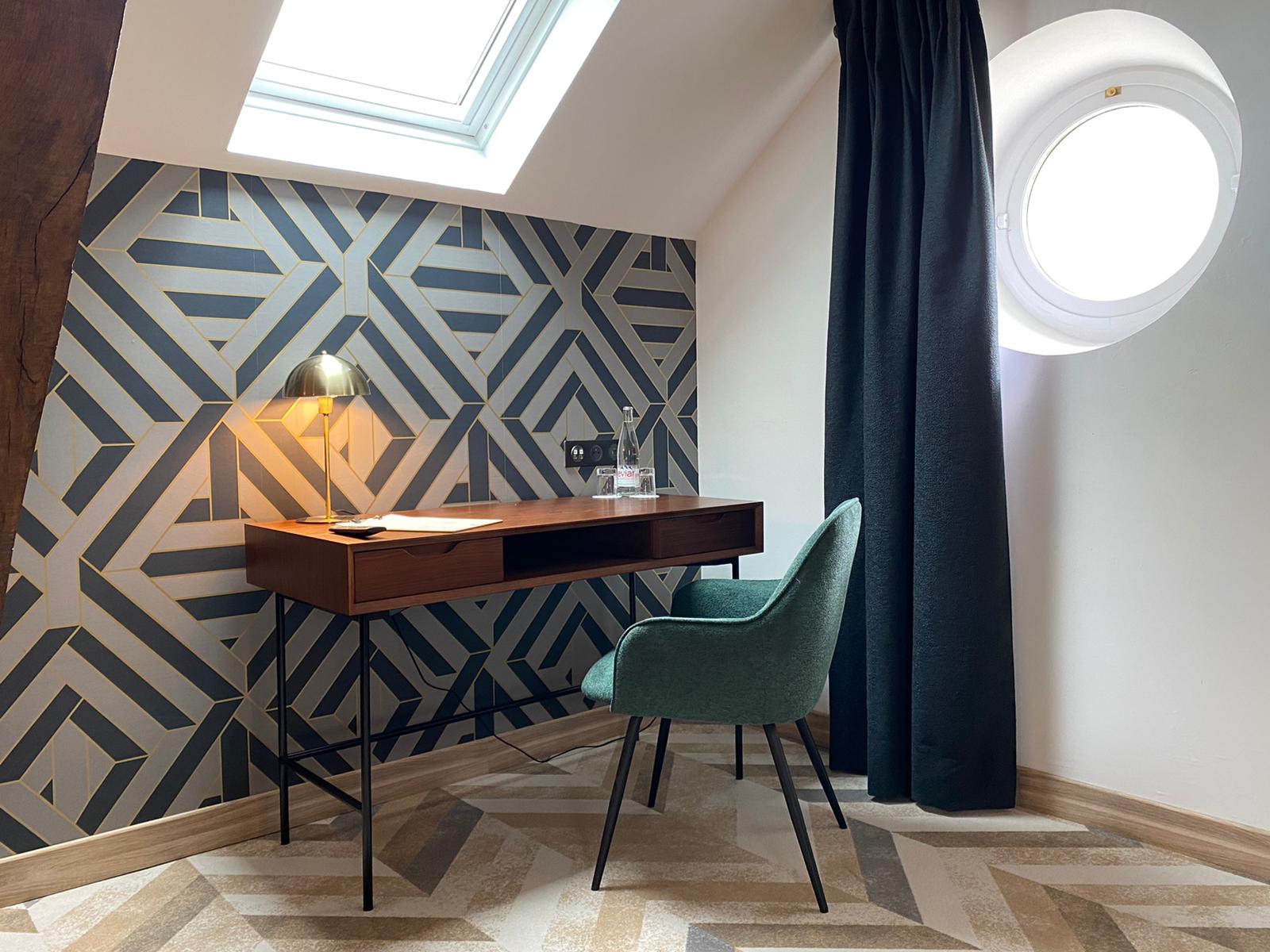 Rénovation d’une maison ancienne en chambre d’hôtes, esprit art déco, bureau bois, fauteuil vert, papier peint geométrique Rénovation d’une maison ancienne en chambre d’hôtes au Merlerault dans le perche normand, esprit art déco avec du papier peint à motifs géométriques, du laiton, un bureau en bois d’acacia et métal noir et un fauteuil en tissu vert