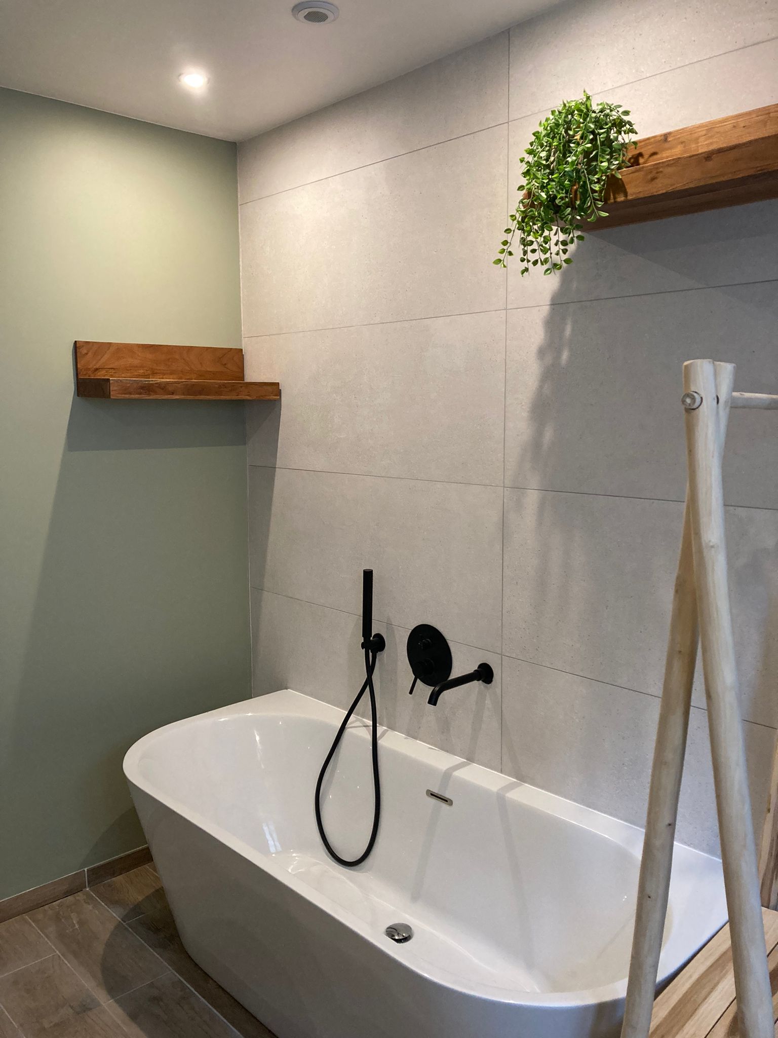 Agrandissement et rénovation d’une salle de bain familiale esprit nature et zen, grande baignoire semi-ilot, mur vert, carrelage en pierre naturelle beige, à Orsay en Essonne