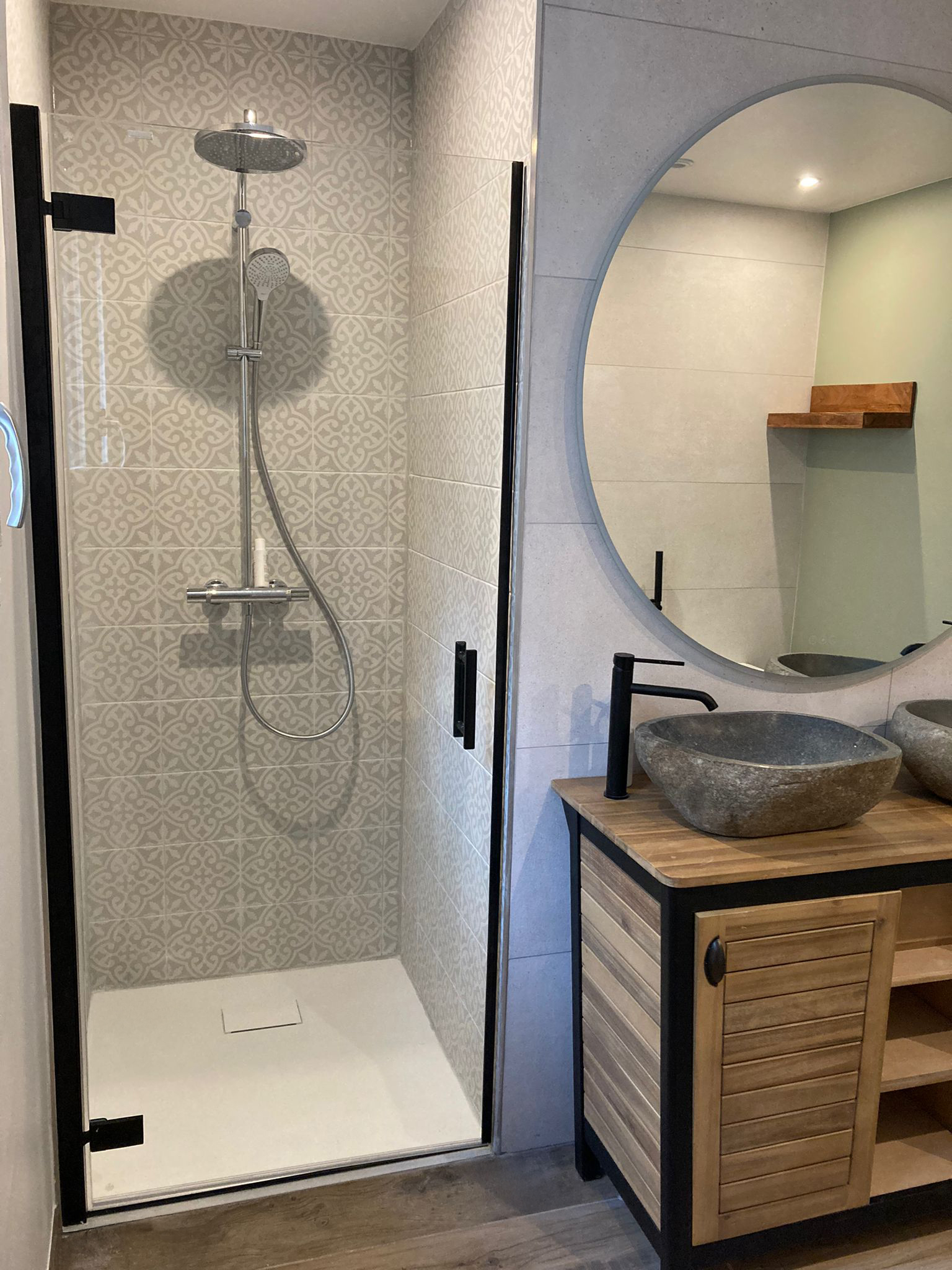Agrandissement et rénovation d’une salle de bain familiale esprit nature et zen, douche en carreaux effet ciment, double vasque en pierre naturelle et meuble en bois massif, grand miroir rond, à Orsay en Essonne