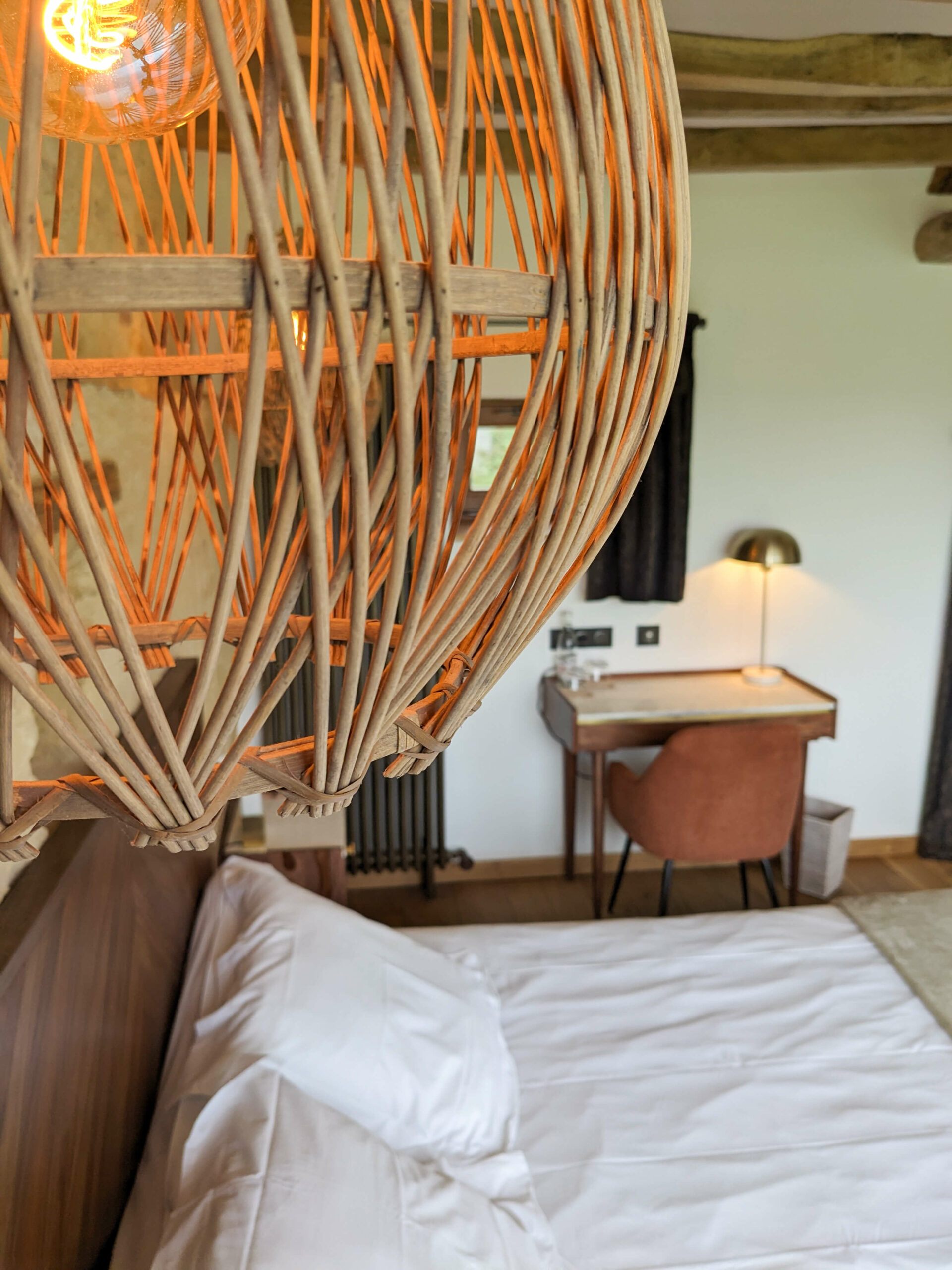 Réhabilitation d'un ancien four à pain en chambre d'hôtes chaleureuse avec poutres apparentes, lumière naturelle, mobilier en bois massif, marbre blanc et laiton, suspension en fibres naturelles, au Merlerault dans le perche normand
