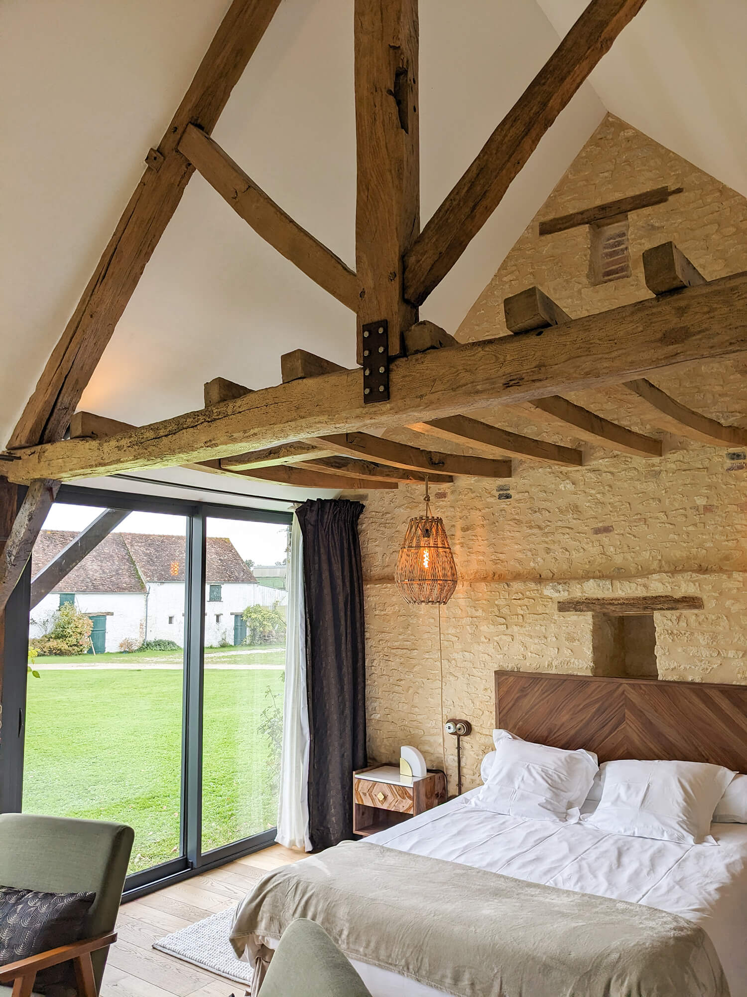 Réhabilitation d'un ancien four à pain en chambre d'hôtes chaleureuse avec poutres apparentes, mur en pierre et lumière naturelle, au Merlerault dans le perche normand