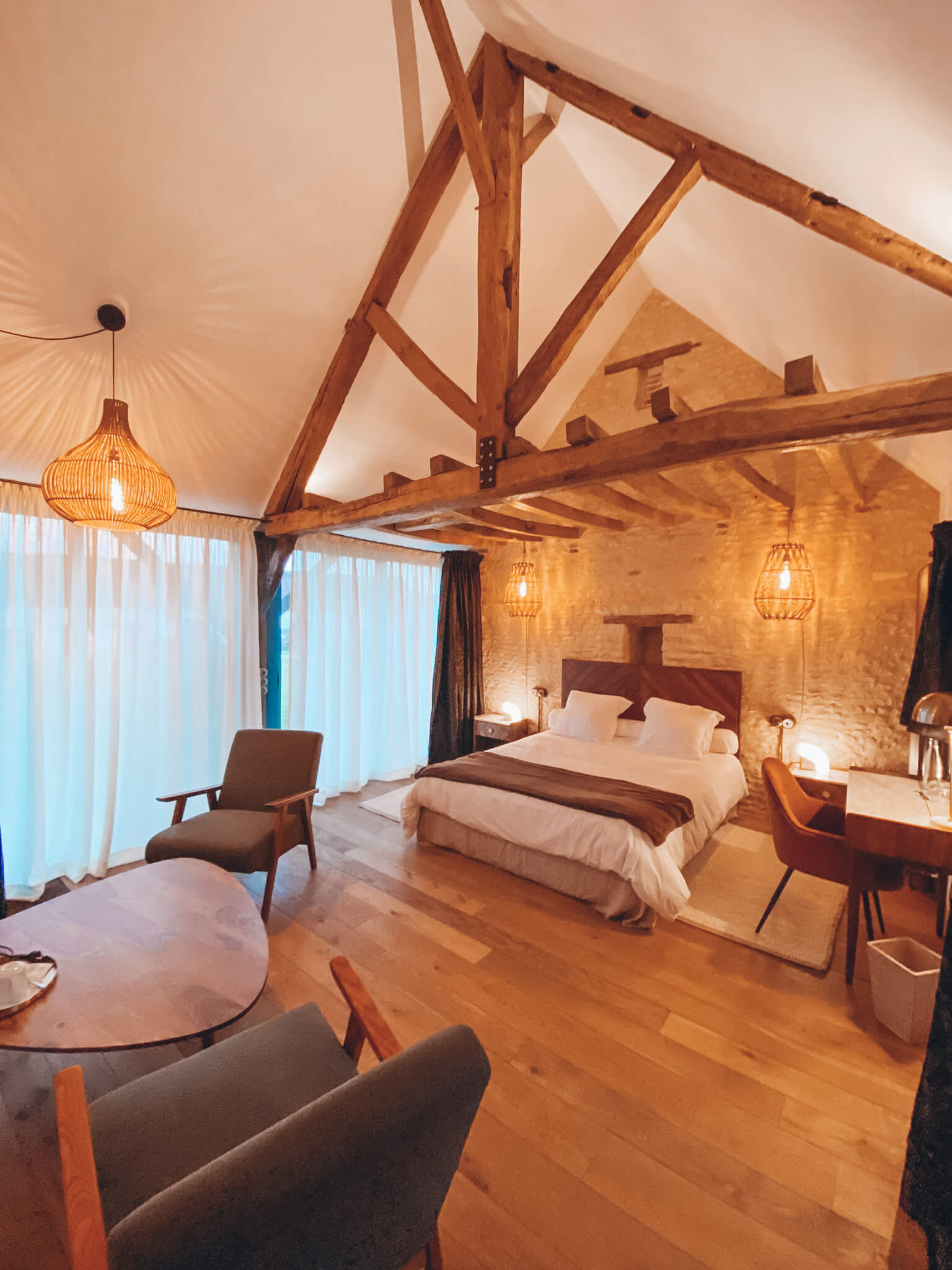 Réhabilitation d'un ancien four à pain en chambre d'hôtes chaleureuse avec poutres apparentes, lumière naturelle, mobilier en bois massif, marbre blanc et laiton, suspension en fibres naturelles, au Merlerault dans le perche normand