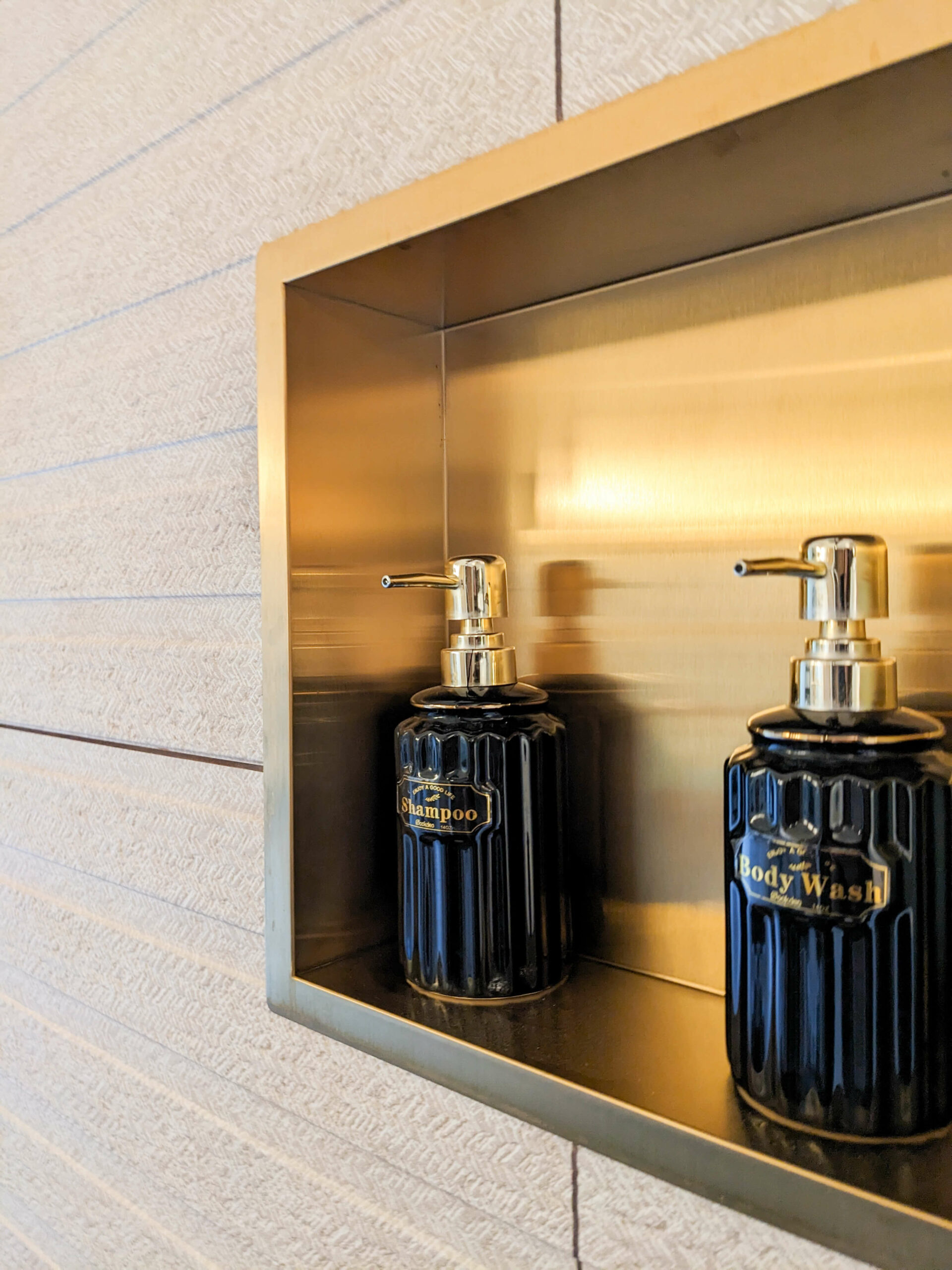 Réhabilitation d'un ancien four à pain en chambre d'hôtes chaleureuse avec douche à l’italienne, détail niche en laiton, au Merlerault dans le perche normand