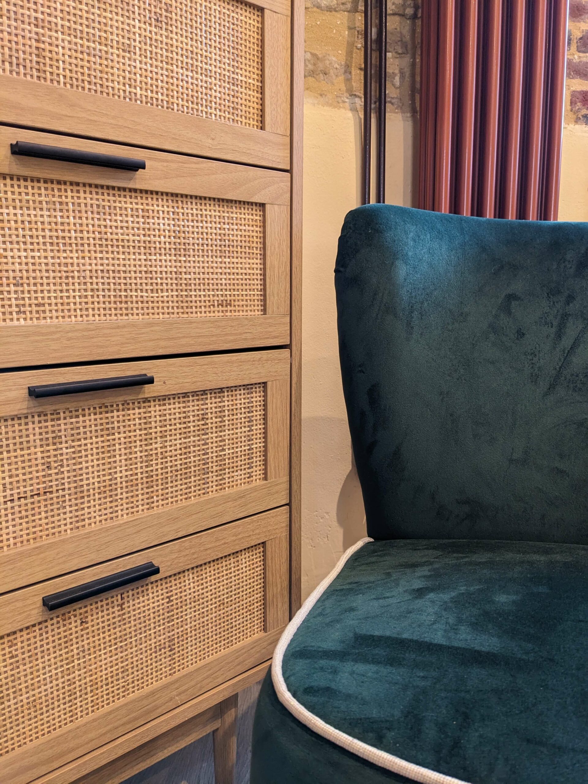 Domaine de Prestal rénovation ancien pigeonnier, détail coin salon avec chiffonnier en bois et cannage, fauteuil en velours vert Réhabilitation d'un ancien pigeonnier en chambre d'hôtes, détail coin salon avec fauteuil en velours vert, chiffonnier en bois et cannage, radiateur fonte couleur cuivrée, au Merlerault dans le perche normand