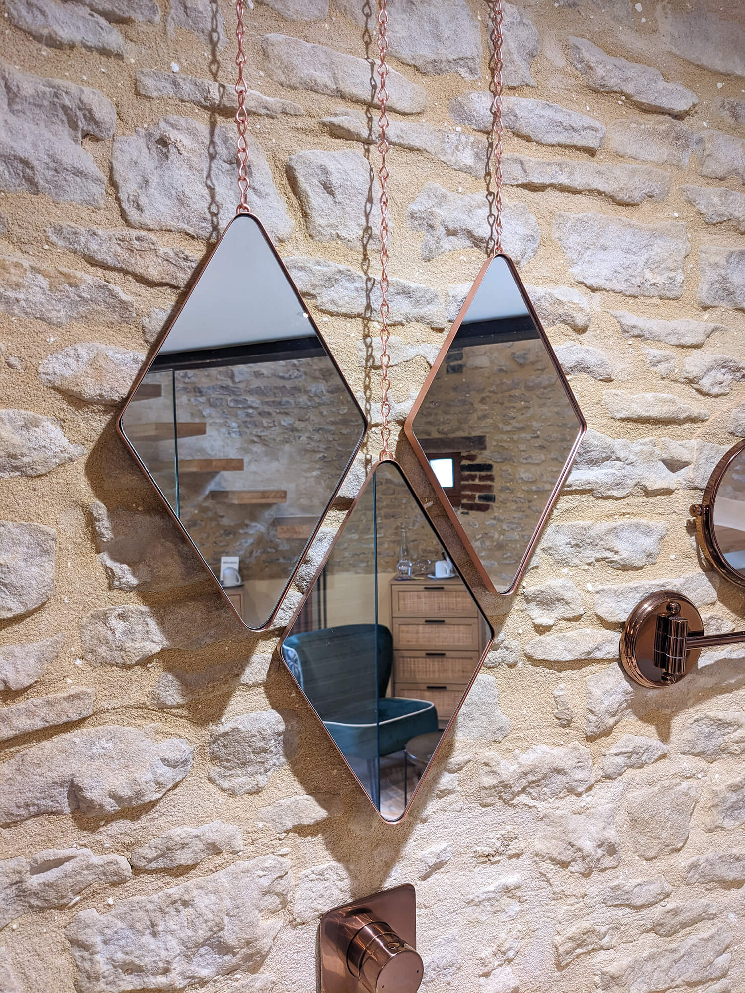 Domaine de Prestal rénovation ancien pigeonnier, détail miroirs triangulaires cuivrés et mur de pierre Réhabilitation d'un ancien pigeonnier en chambre d'hôtes, détail de la salle de douche avec des miroirs insolites en triangles cuivrés, au Merlerault dans le perche normand