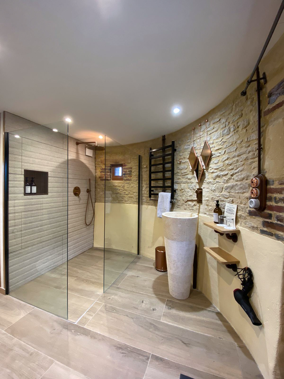 Domaine de Prestal rénovation ancien pigeonnier, salle de douche ouverte, vasque sur pied en marbre et pierre, détails cuivrés Réhabilitation d'un ancien pigeonnier en chambre d'hôtes, salle de douche ouverte avec vasque sur pied en pierre et marbre, robinetterie et détails cuivrés, au Merlerault dans le perche normand