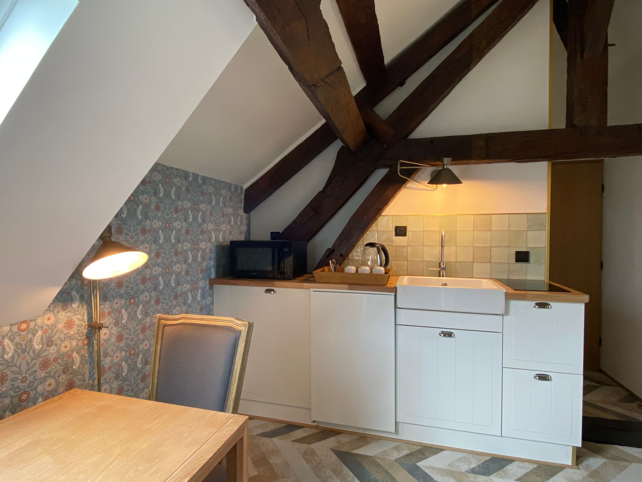 Rénovation d’une maison ancienne en chambre d’hôtes, esprit campagne classique avec des couleurs pastel, kitchenette Rénovation d’une maison ancienne en chambre d’hôtes au Merlerault dans le perche normand, esprit campagne classique avec des couleurs pastel, kitchenette avec crédence zelliges vert d'eau, papier peint floral bleu et table bois