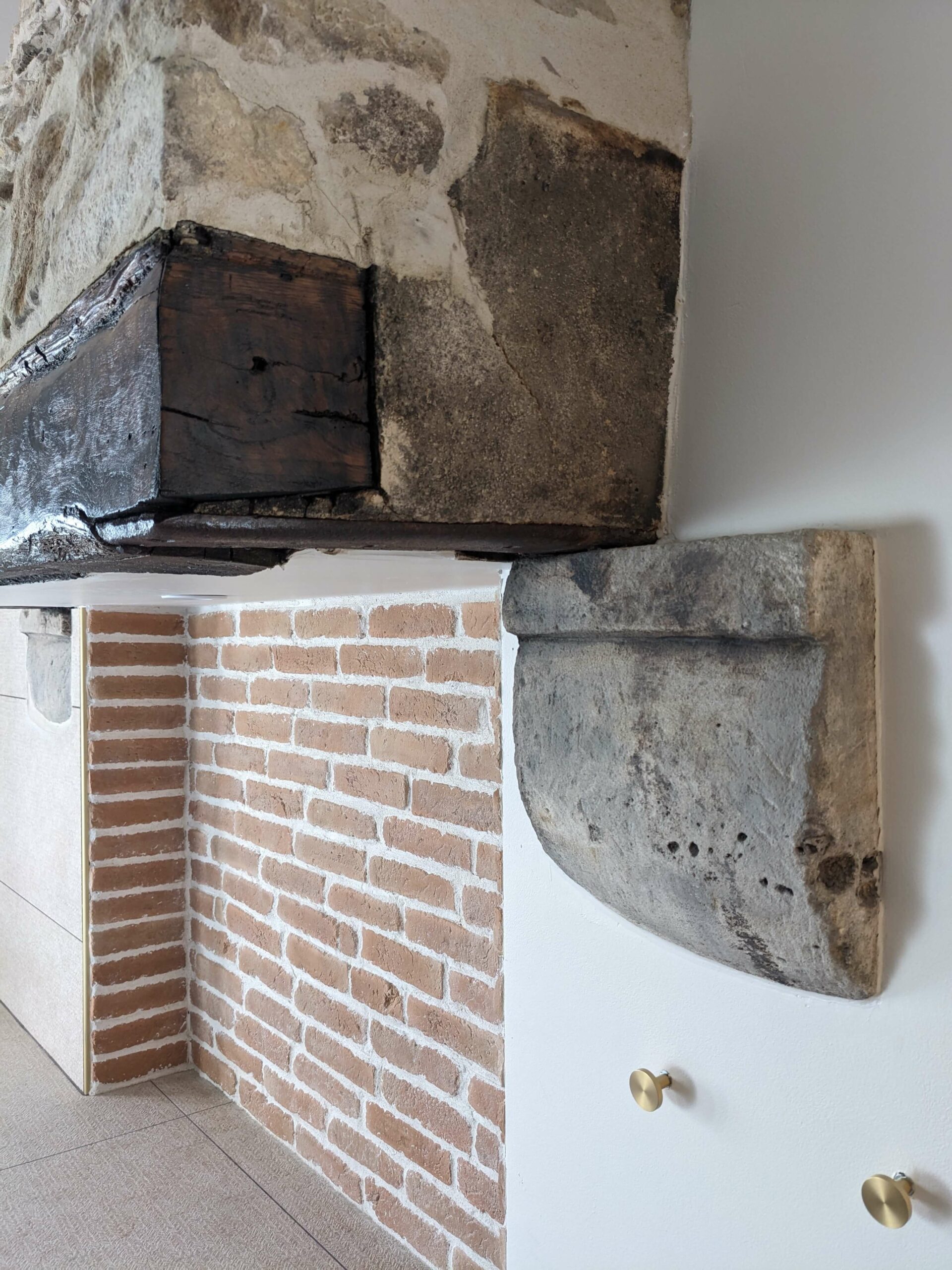Réhabilitation d'un ancien four à pain en chambre d'hôtes, salle de bain avec ancienne cheminée en pierre, brique, patères laiton, au Merlerault dans le perche normand