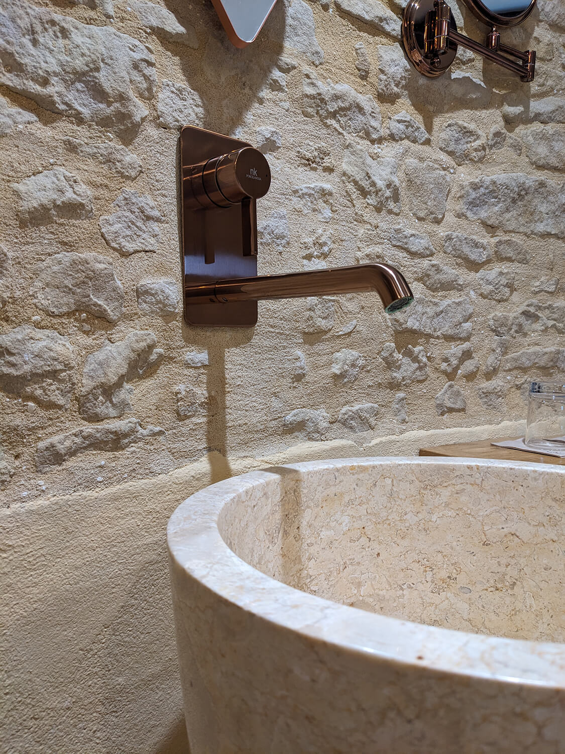 Réhabilitation d'un ancien pigeonnier en chambre d'hôtes, détail de la salle de douche avec vasque sur pied en pierre et marbre, robinetterie cuivrée, au Merlerault dans le perche normand