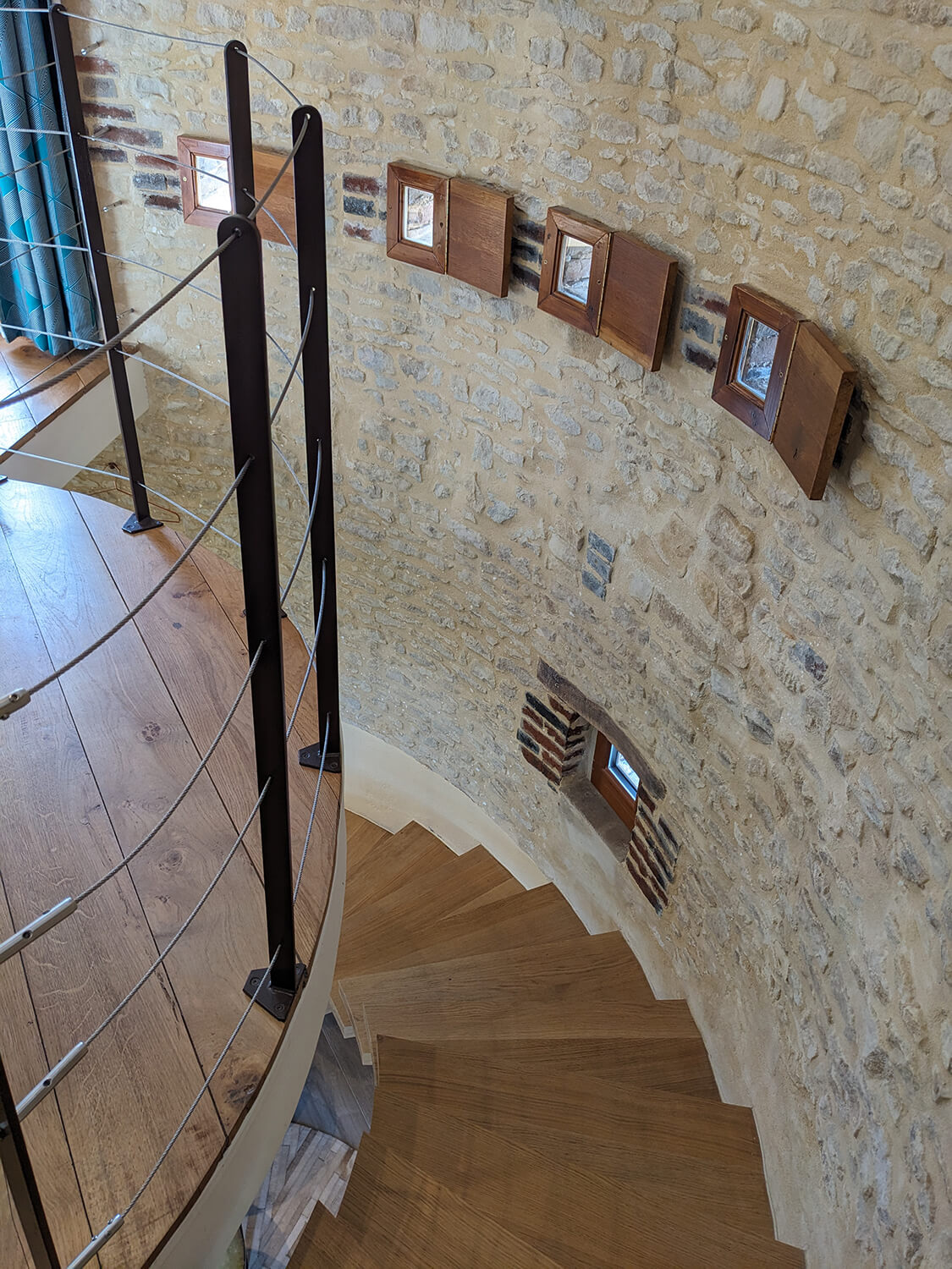 Réhabilitation d'un ancien pigeonnier en chambre d'hôtes, détail escalier circulaire, petites fenêtres sur mesure en bois, garde-corps métalliques filaires, au Merlerault dans le perche normand