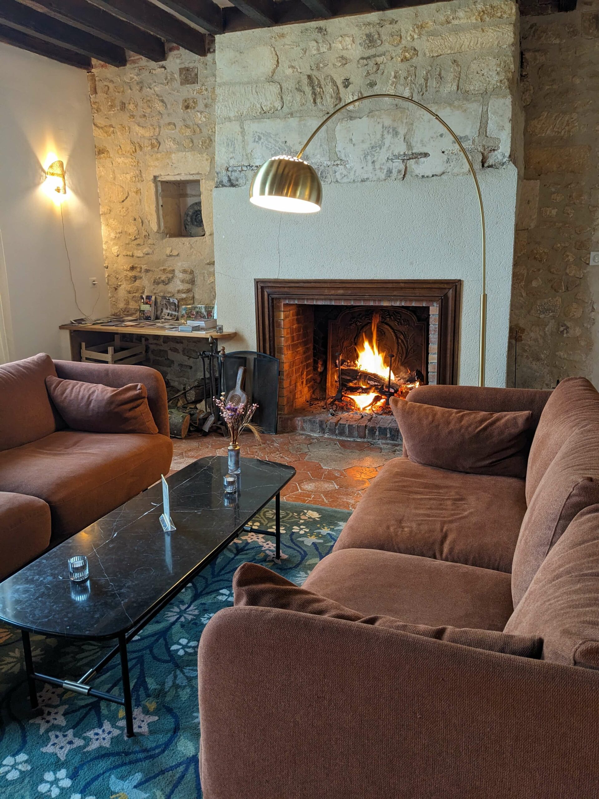 Domaine de Prestal rénovation maisons d'hotes, boudoir avec salon cheminée, canapés rouille, tapis floral, au Merlerault dans le perche normand