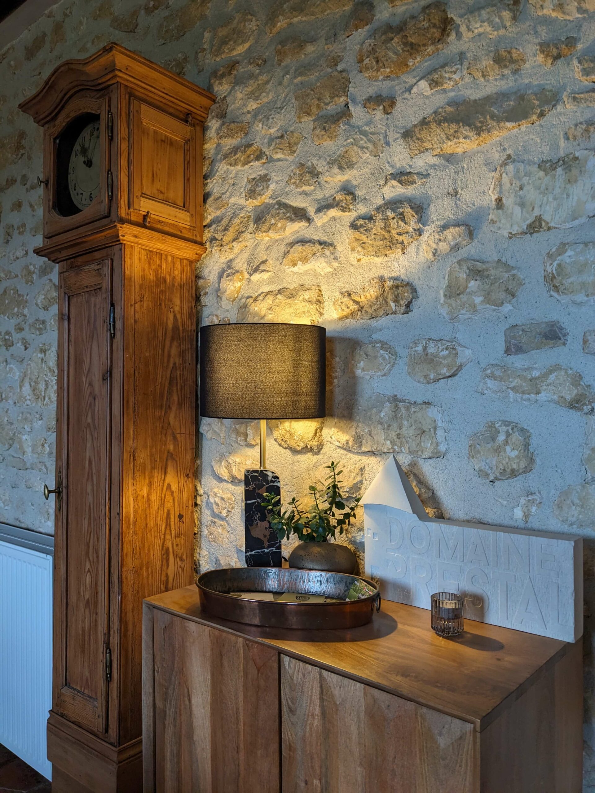 Domaine de Prestal rénovation maisons d'hotes, boudoir, horloge ancienne, console avec logo du Domaine taillé dans la pierre
