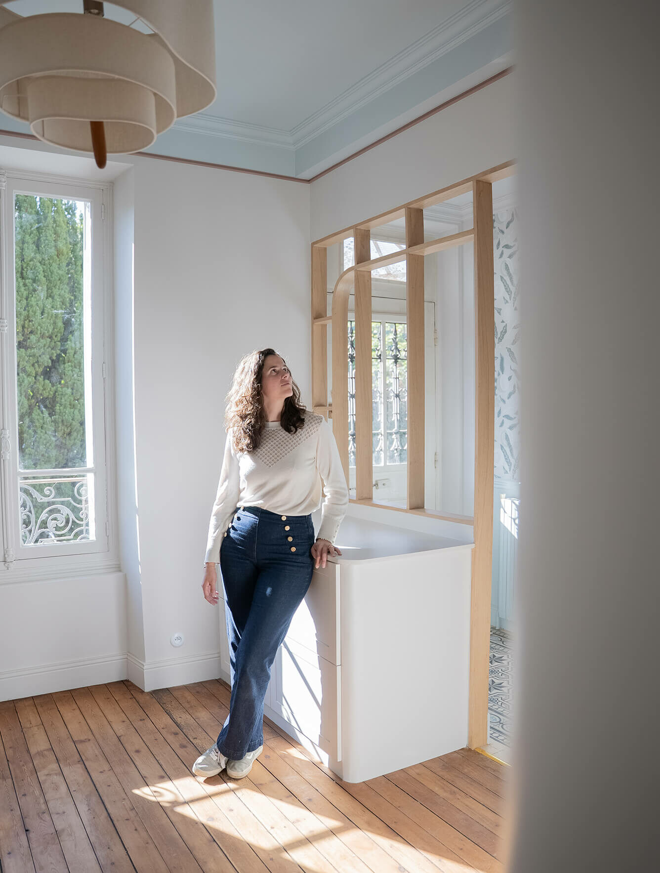 Portrait de Pauline Lavocat, architecte d'intérieur à Chalo-Saint-Mars en Essonne, photographiée dans l'entrée d'une maison familiale entièrement rénovée par l'agence.
