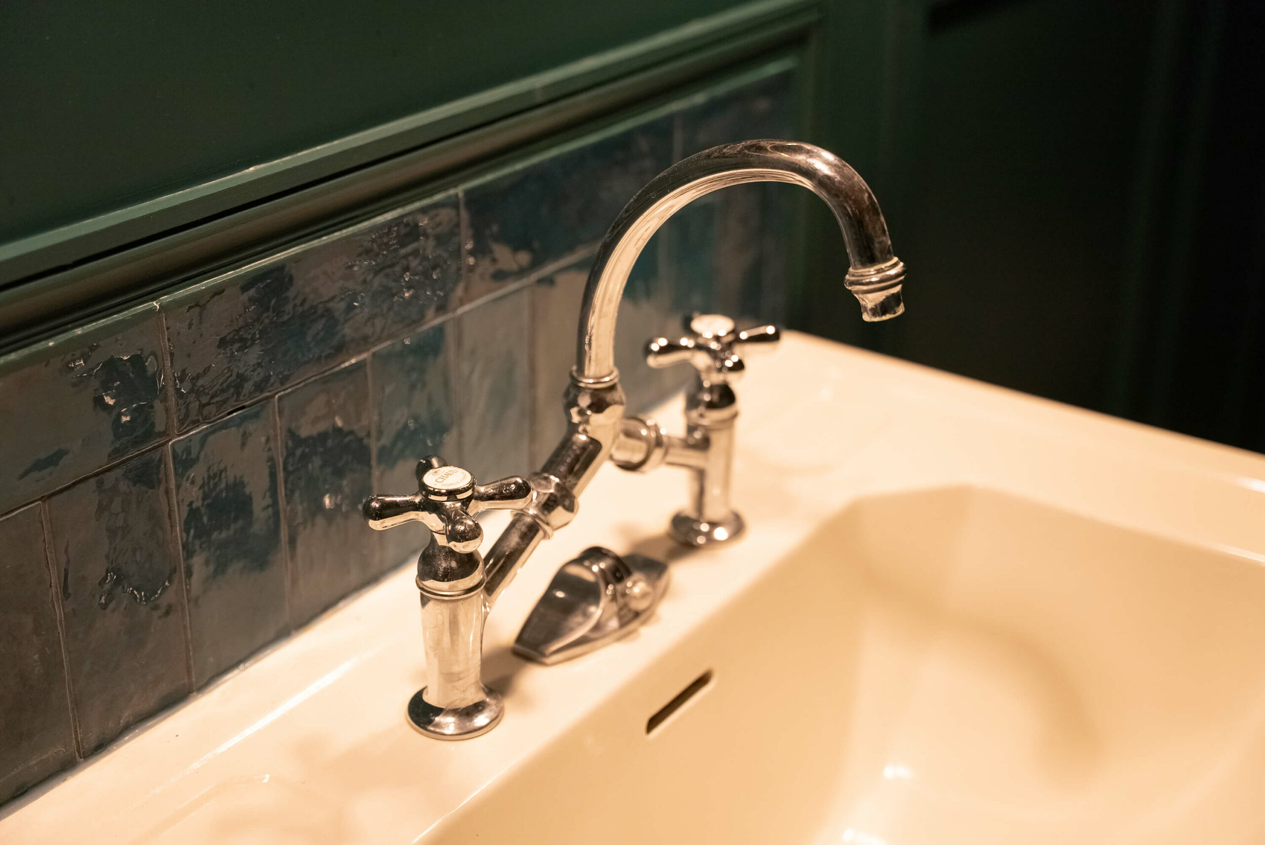 Rénovation d’une maison meulière à Bonnières, retrouver le charme de l’ancien, lavabo et robinetterie anciennes, zelliges vert foncé et moulures