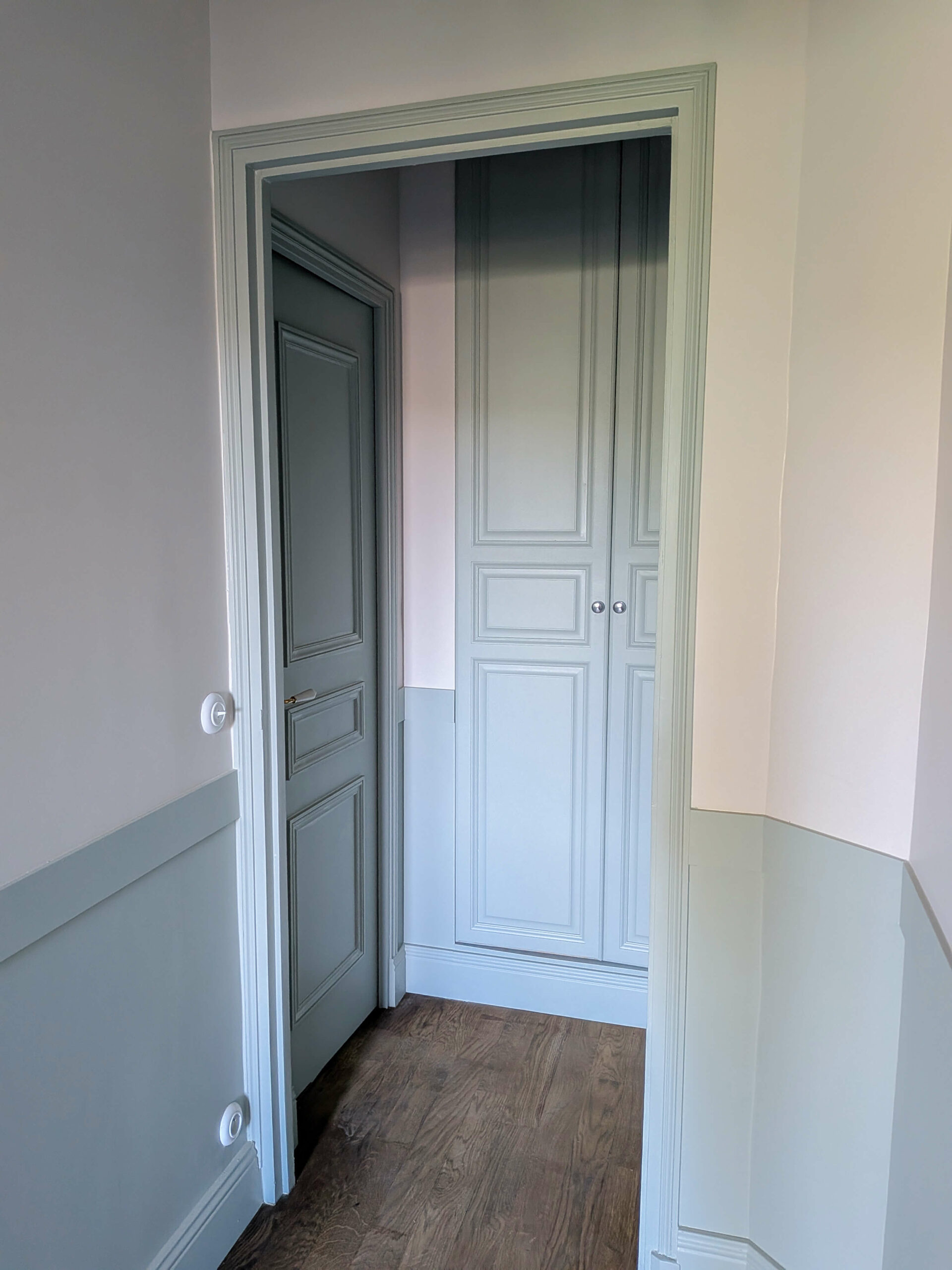 Rénovation d’une maison meulière à Bonnières, retrouver le charme de l’ancien, le dégagement avec création d'un placard en réutilisant d'anciennes portes, soubassements peint en vert de gris et parquet neuf en chêne massif