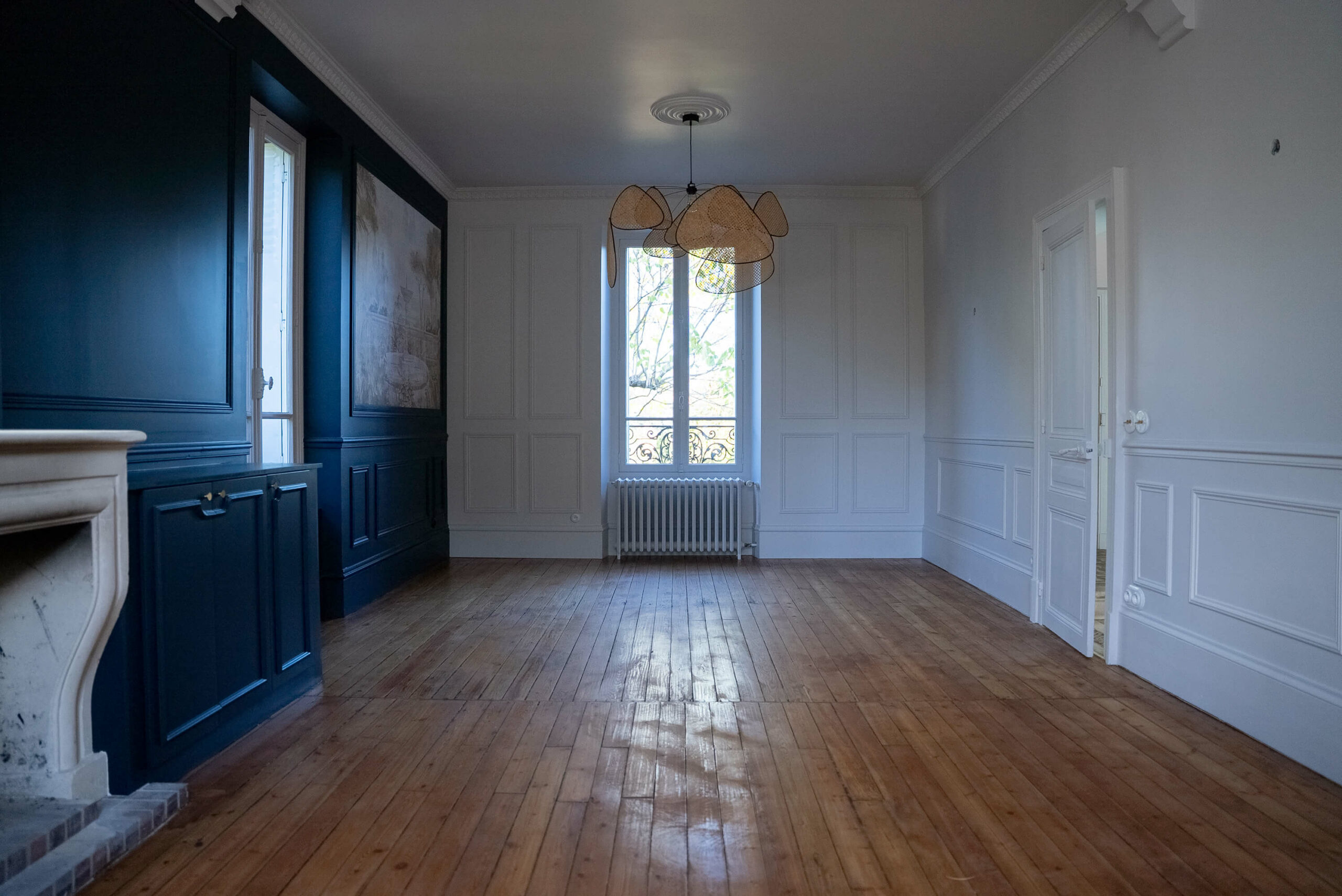 Rénovation d’une maison meulière à Bonnières, retrouver le charme de l’ancien, salle à manger avec mur bleu mouluré, papier peint encadré, corniches et cimaises, le parquet ancien est conservé