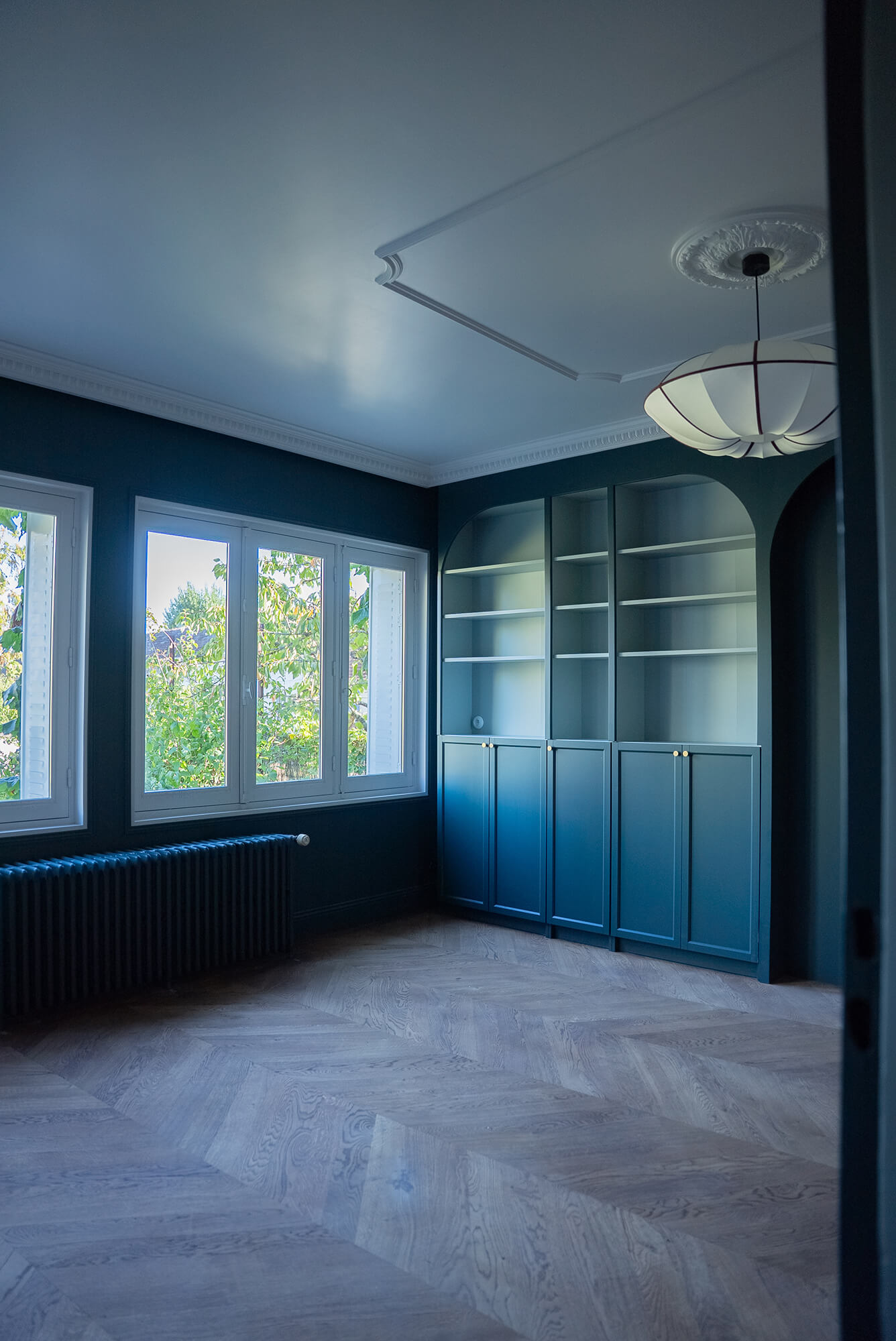 Rénovation d’une maison meulière à Bonnières, retrouver le charme de l’ancien, salon bibliothèque sur mesure vert foncé avec corniches et cimaises, parquet neuf en chêne massif en point de hongrie