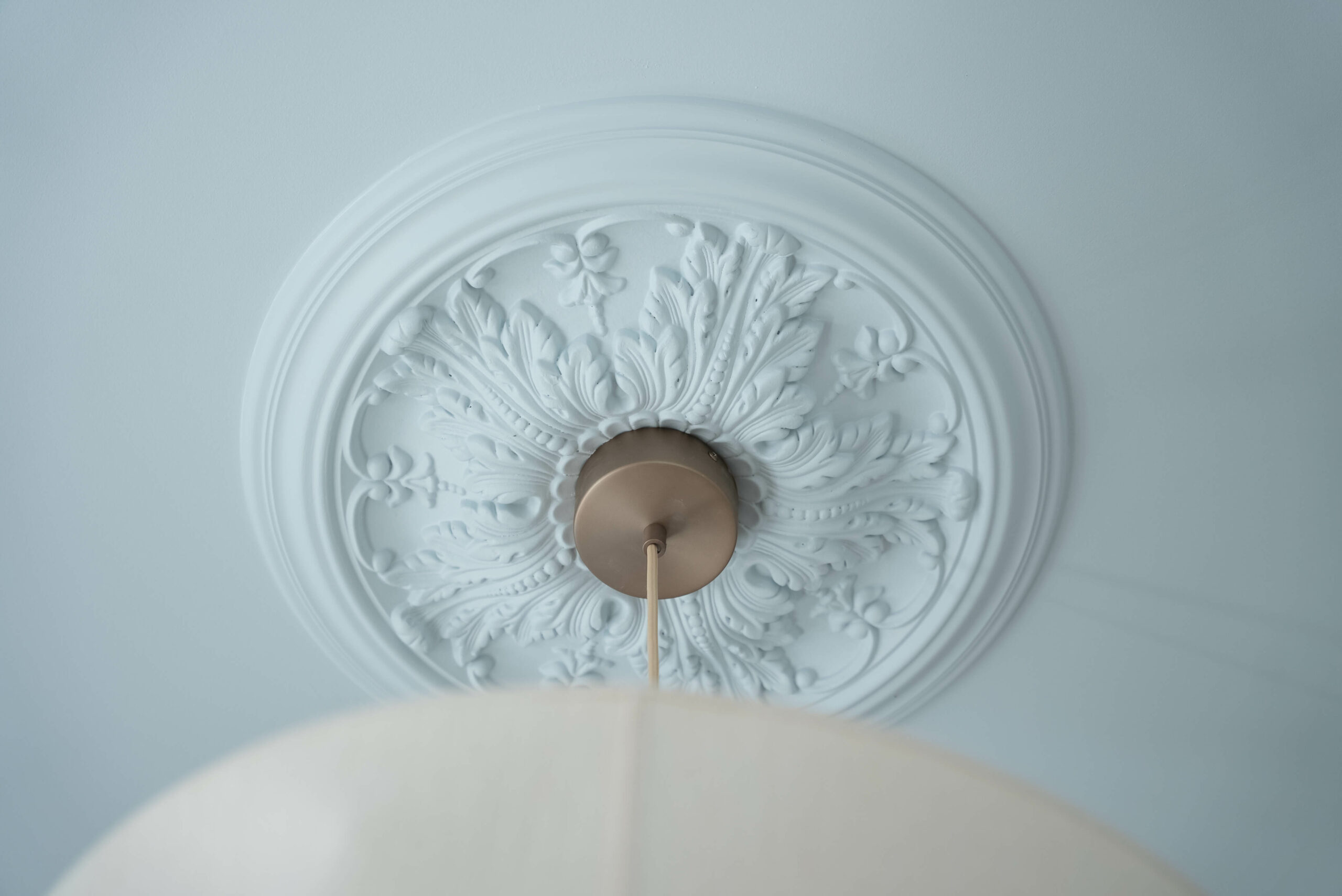 Rénovation d’une maison meulière à Bonnières, retrouver le charme de l’ancien, zoom sur la rosace moulurée du luminaire, plafond bleu ciel